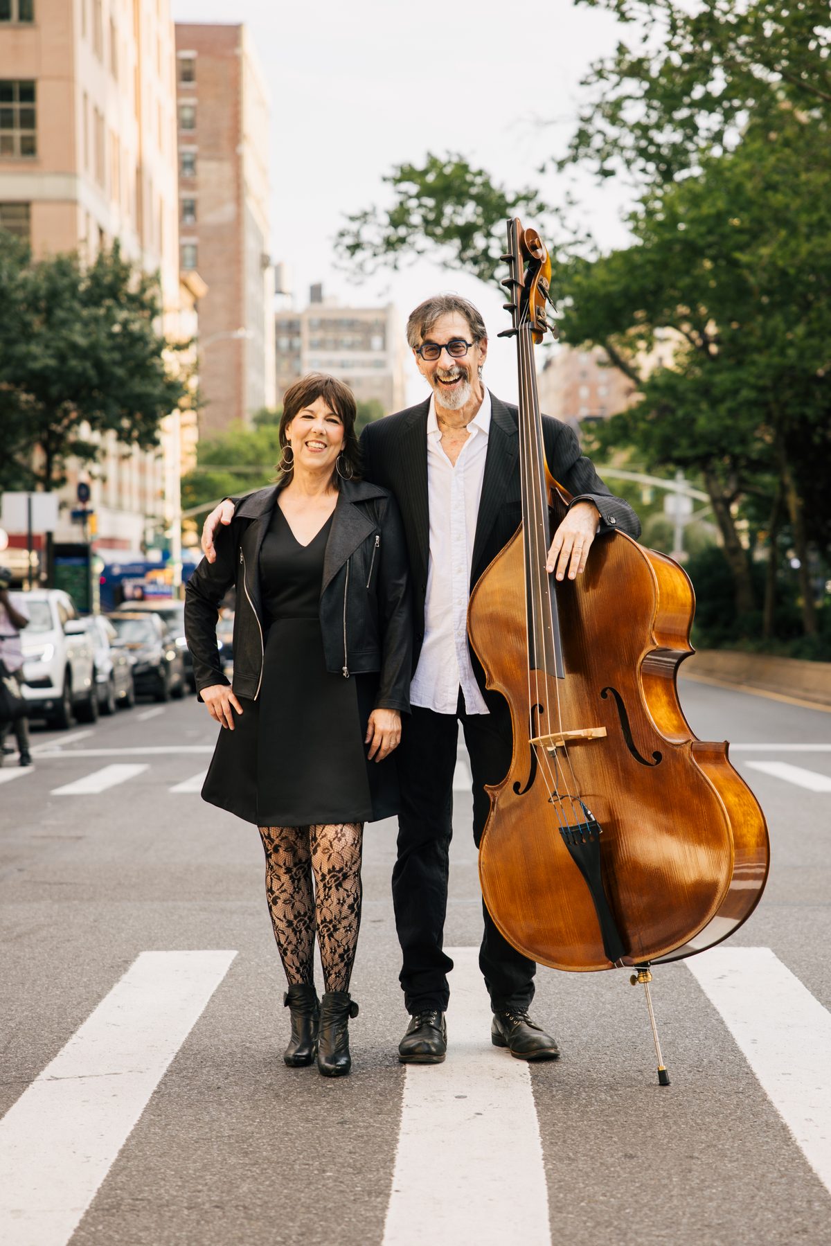 Beth Falcone and Ritt Henn standing in a New York crosswalk, Ritt with his upright bass.