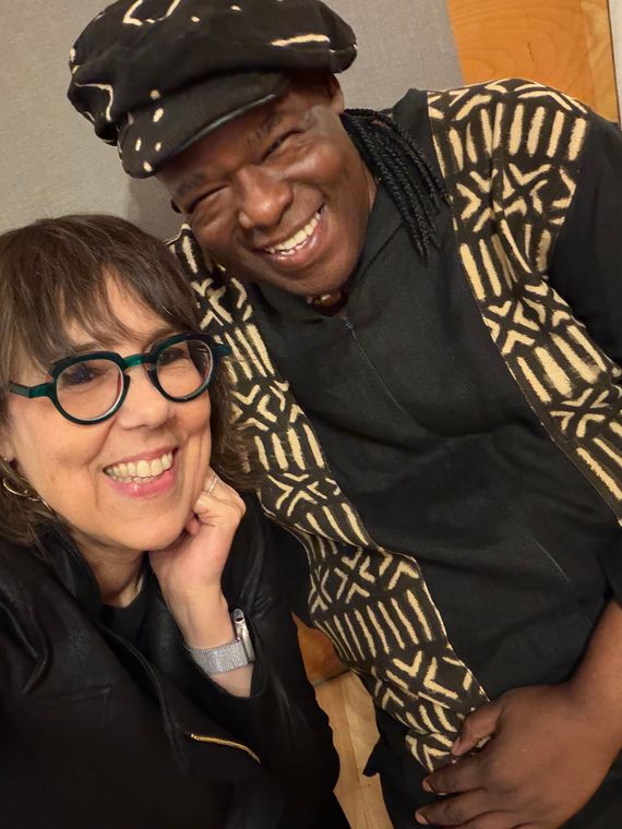 Two musicians smiling in a studio selfie.