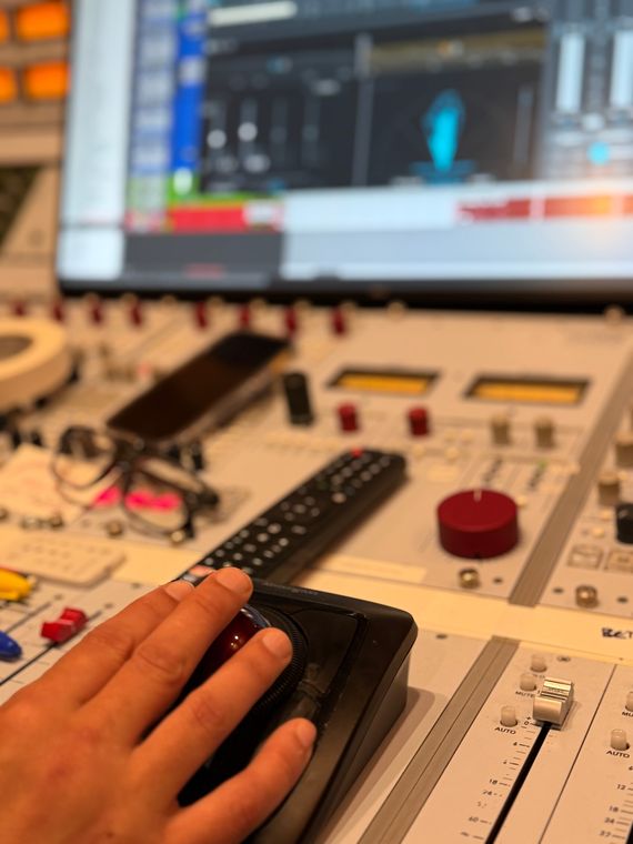 An engineer&rsquo;s hand on the trackball at the mixing console.