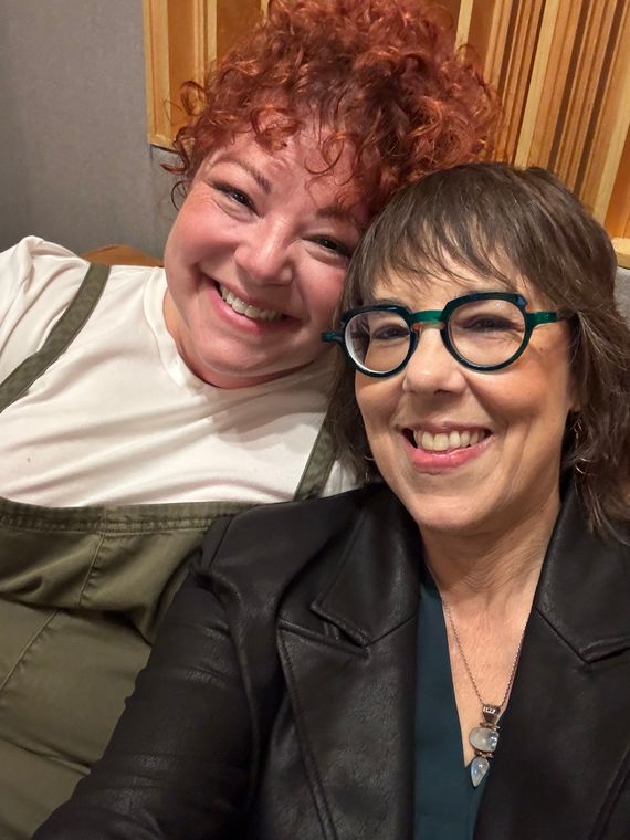 Two musicians smiling in a selfie in the studio lounge.