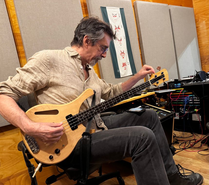 Ritt Henn tuning an electric bass in the control room.