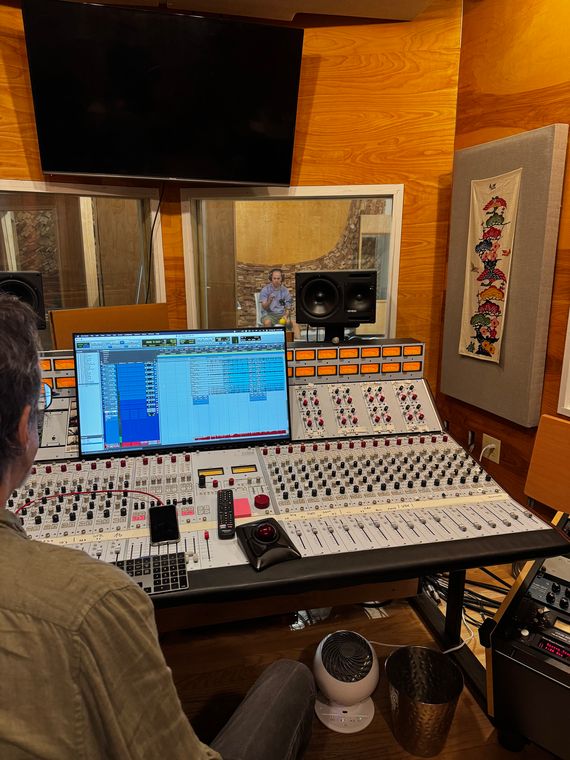 The view from the console through the glass to a musician in the live room.