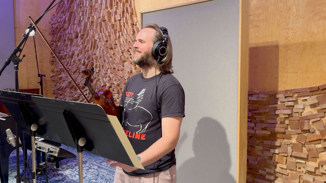 Reid Jenkins smiling between takes, violin in hand.
