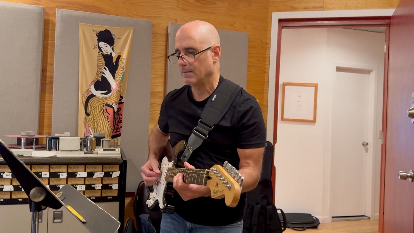 Tony Romano playing electric guitar in the studio.